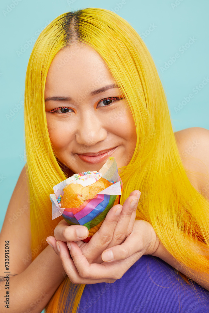 Smiling young woman with yellow hair, holding cup cake Smiling young woman with yellow hair, holding cup cake