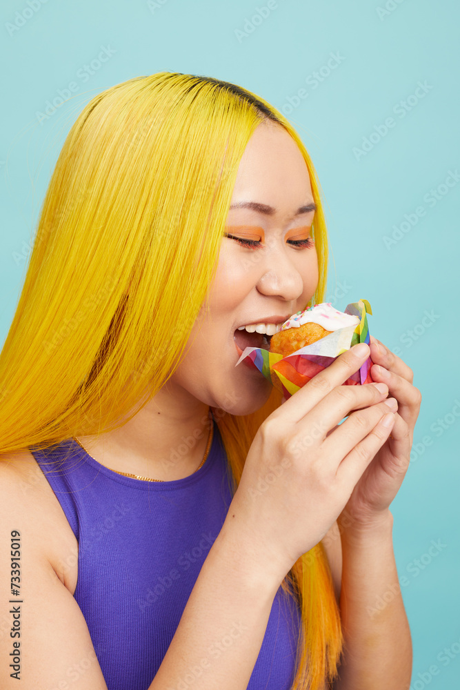 Smiling young woman with yellow hair, eating cup cake Smiling young woman with yellow hair, eating cup cake