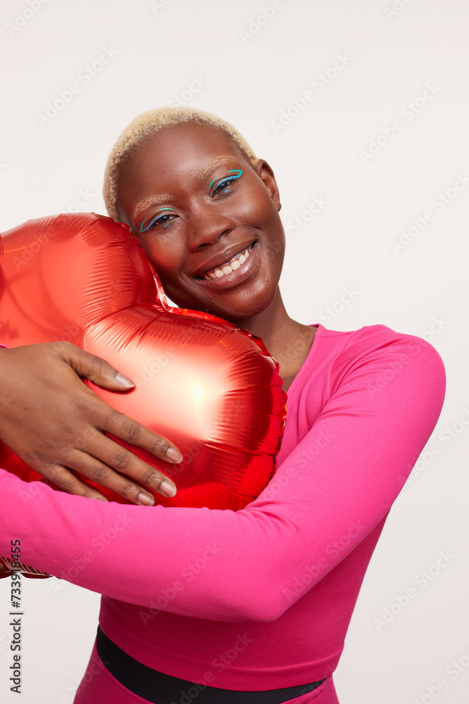 Smiling woman with short white hair, embracing heart shape balloon Smiling woman with short white hair, embracing heart shape balloon