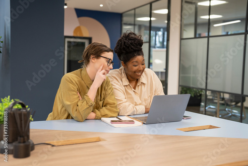 Smiling businesswomen working together on laptop in office
