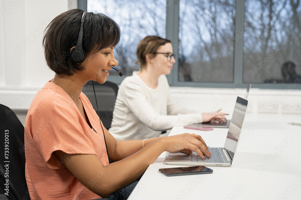 Businesswomen working on laptops in office Businesswomen working on laptops in office