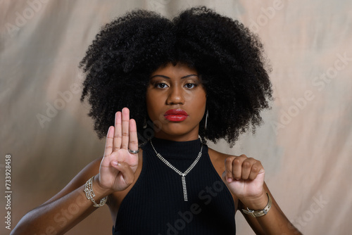 black woman gestures with her hand for help, denounces aggression, cowardice, violence against women, no to racism photo
