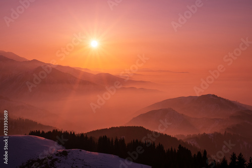 Magical view of a mountain valley shrouded in a light haze at sunset; magical atmosphere of a sunset in the highlands