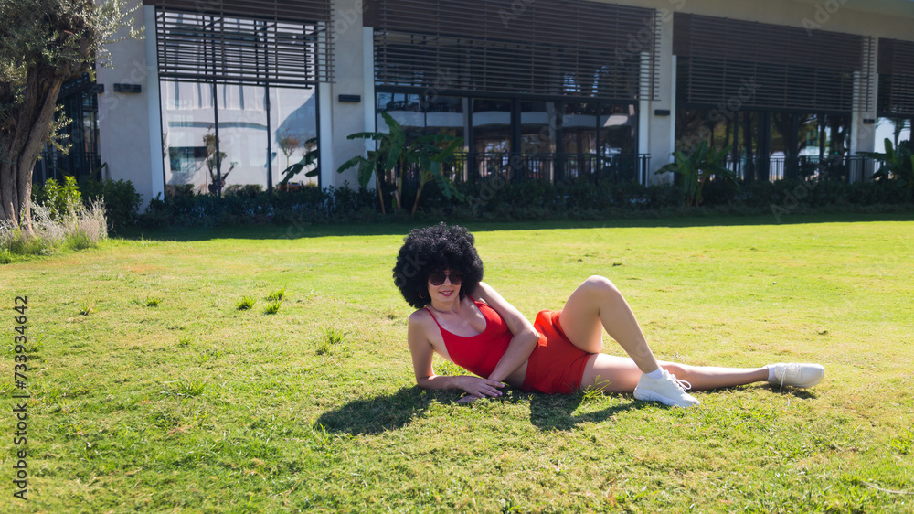 Fototapeta premium Athletic girl resting lying grass after physical exercise.