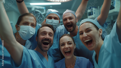 Medical team includes surgeon, nurse, assistant are celebrating a successful surgery in operating room photo