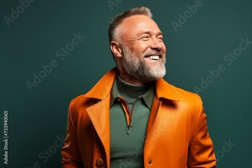 Portrait of a smiling senior man in a orange jacket. Studio shot.