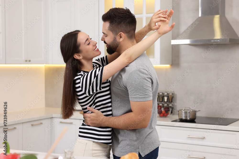 Lovely couple enjoying time together while cooking in kitchen Lovely couple enjoying time together while cooking in kitchen