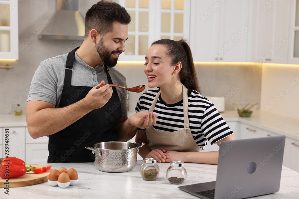 Lovely young couple cooking together in kitchen Lovely young couple cooking together in kitchen