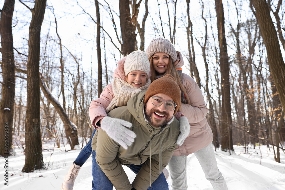 Happy family spending time together in snowy forest
