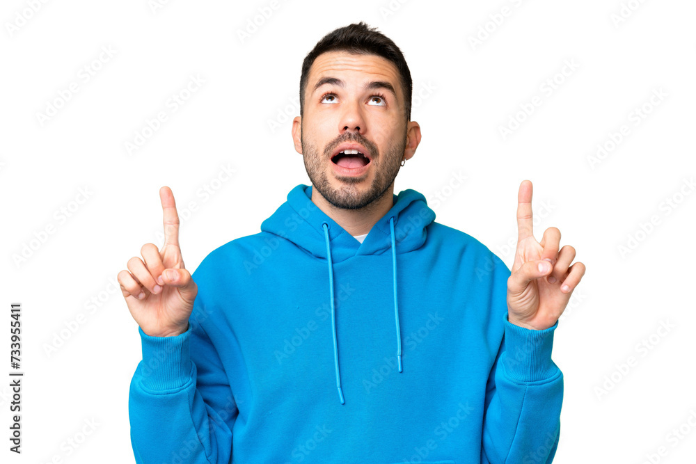 Young handsome caucasian man over isolated chroma key background surprised and pointing up Young handsome caucasian man over isolated chroma key background surprised and pointing up