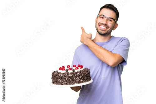 Canvas Print Young caucasian man holding birthday cake isolated on green chrome background po