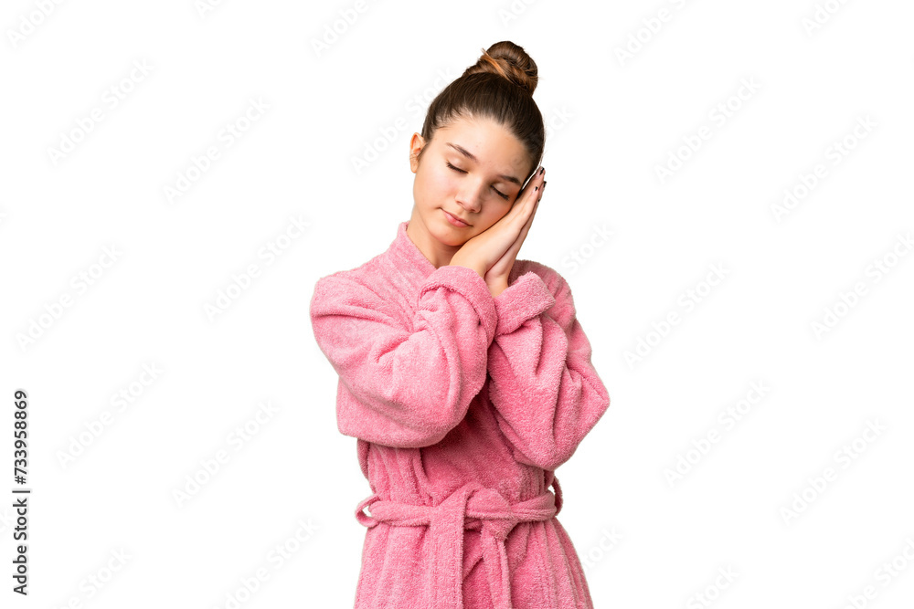 Teenager girl in a bathrobe over isolated chroma key background making sleep gesture in dorable expression Teenager girl in a bathrobe over isolated chroma key background making sleep gesture in dorable expression