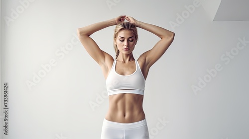 Young white fitness woman in sportswear with ponytail standing over white wall background, stretching hands