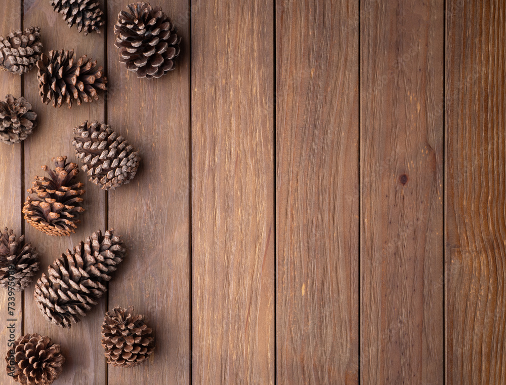 Fototapeta premium Group of pinecones over wooden table with copy space
