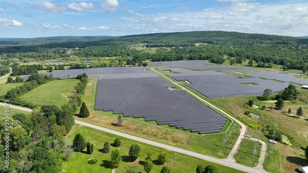 Solar farm in green landscape making renewable sustainable energy for local homes and business