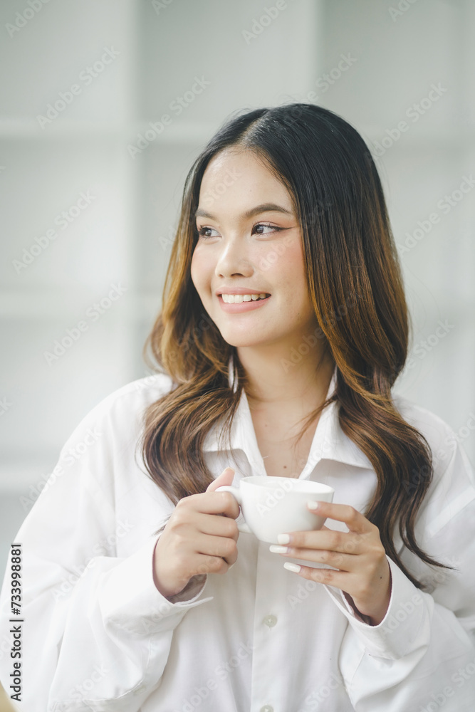 Beautiful young concentrated business woman wearing shirt using laptop while standing in modern workspace Beautiful young concentrated business woman wearing shirt using laptop while standing in modern workspace
