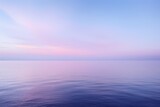 A serene seascape at dawn, featuring a gradient sky transitioning from deep blue to soft lavender, reflecting on calm waters.