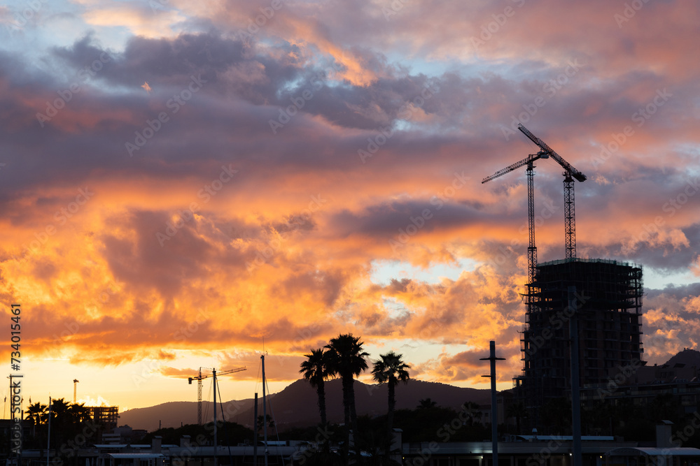 Construction Industry with Cranes, Sunset with Orange Sky Construction Industry with Cranes, Sunset with Orange Sky