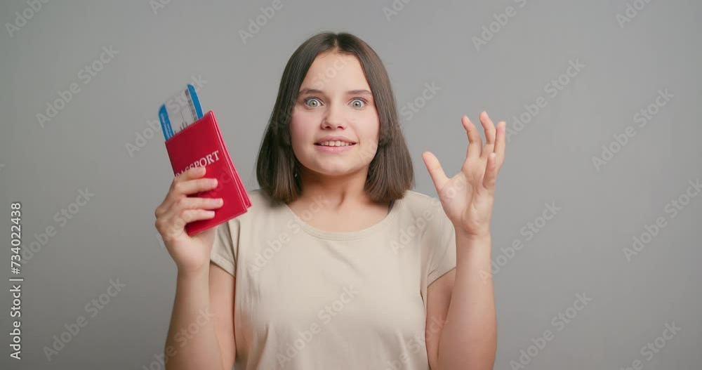 Traveler tourist latin teenager girl wear beige shirt hold passport tickets do winner gesture isolated on gray background studio. Passenger travel abroad on weekends getaway. Air flight journey Traveler tourist latin teenager girl wear beige shirt hold passport tickets do winner gesture isolated on gray background studio. Passenger travel abroad on weekends getaway. Air flight journey