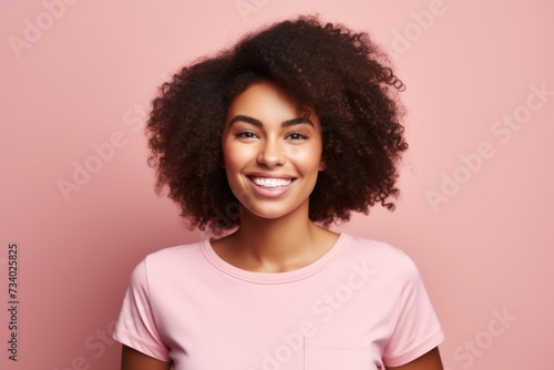 Young african american woman with afro hairstyle on pink background