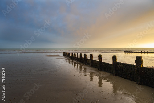 Sunset on Felpham beach on a winter evening, West Sussex, England. View of the wooden groynes. © veronique
