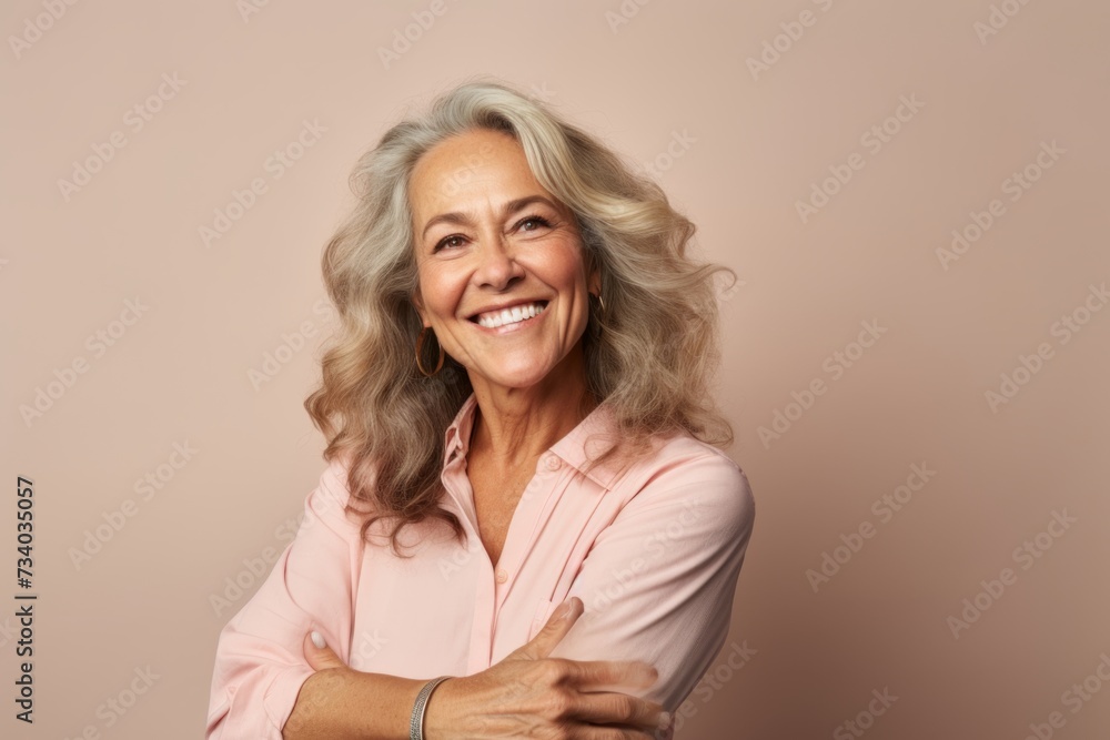 Portrait of a smiling senior woman with grey hair in a pink blouse on a beige background Portrait of a smiling senior woman with grey hair in a pink blouse on a beige background