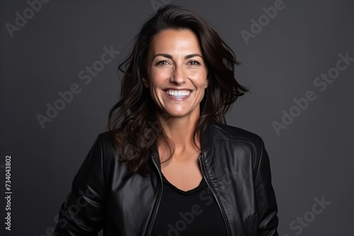 Portrait of a beautiful woman in leather jacket smiling at the camera © Loli