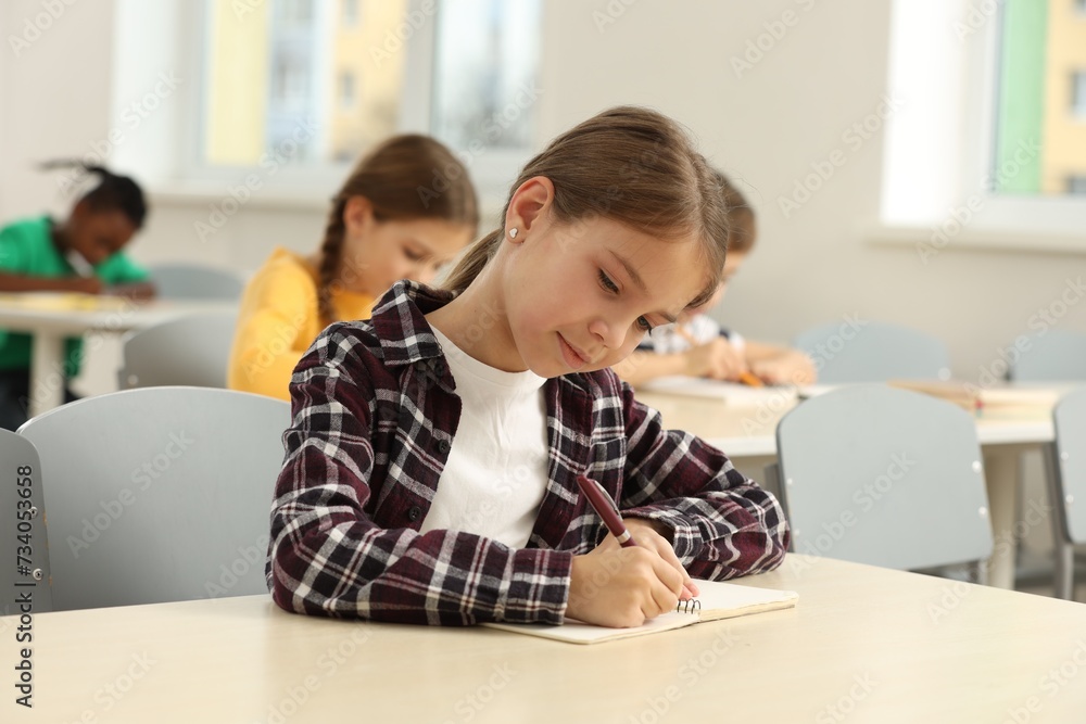 Cute little girl studying in classroom at school Cute little girl studying in classroom at school