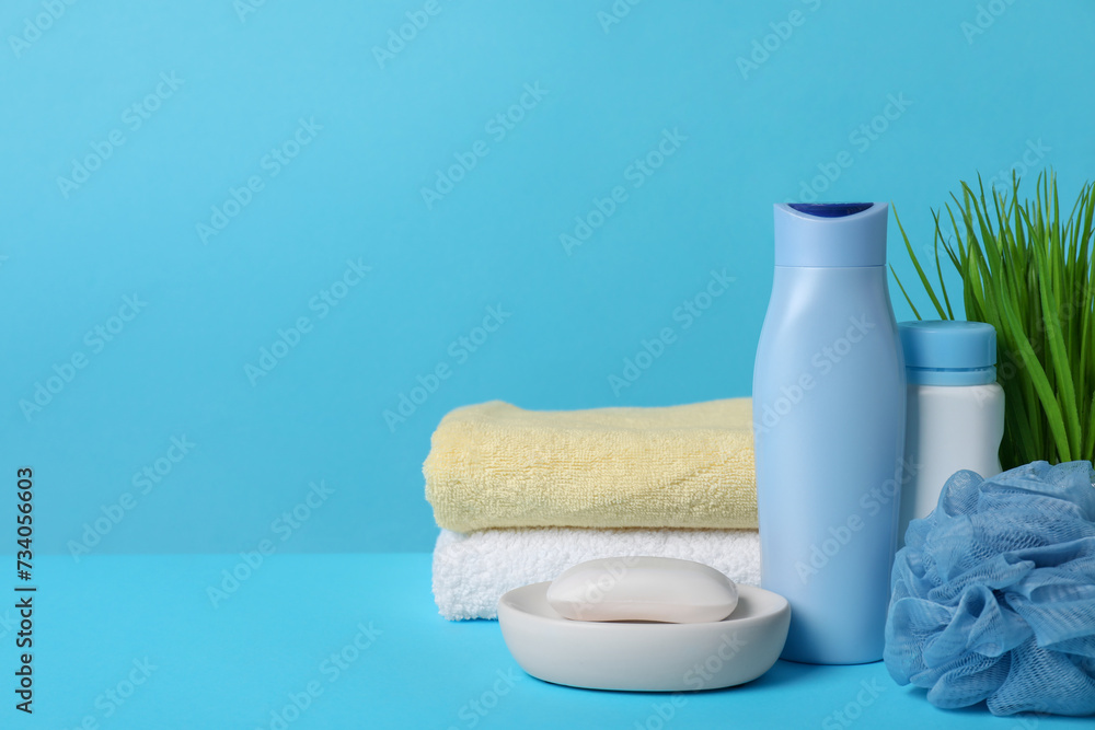 Baby cosmetic products, sponge and towels on light blue background. Space for text Baby cosmetic products, sponge and towels on light blue background. Space for text