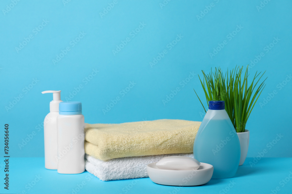 Baby cosmetic products and towels on light blue background Baby cosmetic products and towels on light blue background