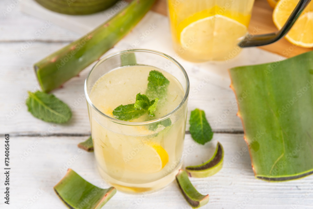 Aloe lemonade, homemade detox drink with lemon, aloe vera and mint on white wooden background copy space Aloe lemonade, homemade detox drink with lemon, aloe vera and mint on white wooden background copy space