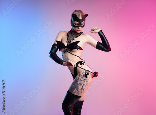 Sexy girl in lingerie, leather cat mask for BDSM, costume for sex games on a pink bright background copy paste