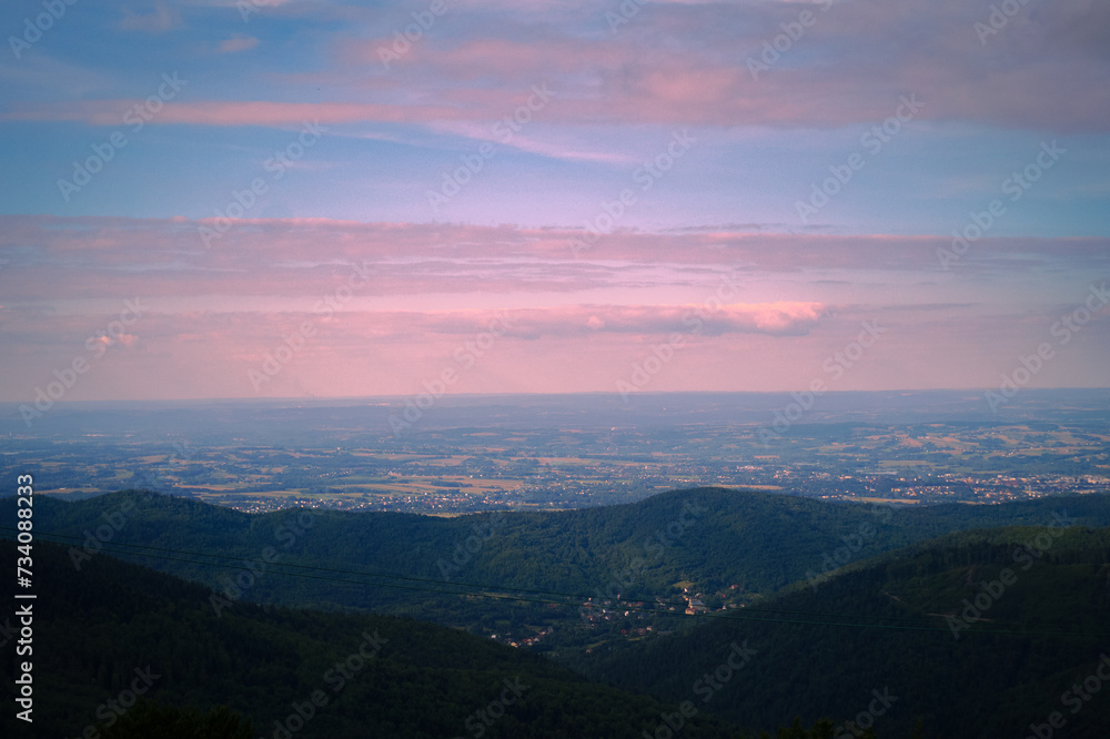 Pink clouds, sunrise over the mountains, view of the village in the mountains