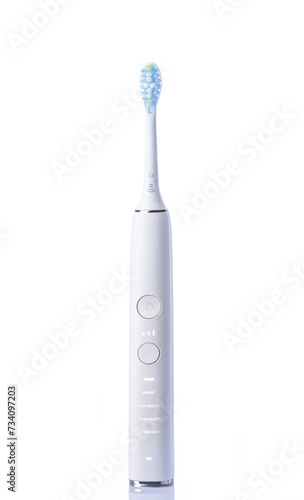 a white electric toothbrush with a green toothbrush head