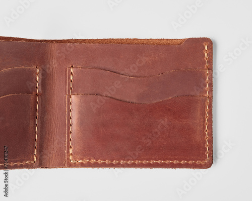 Open brown leather wallet with card pockets and hidden embossed message