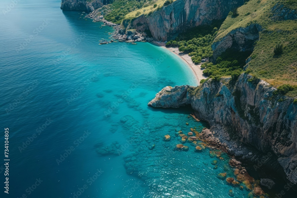 Drone shot of turquoise waters along a rugged coastline