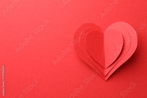 Paper hearts on red background, top view. Space for text