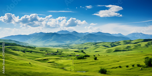 Beautiful landscape with green meadows and mountains under blue sky. © Graphicsstudio 5