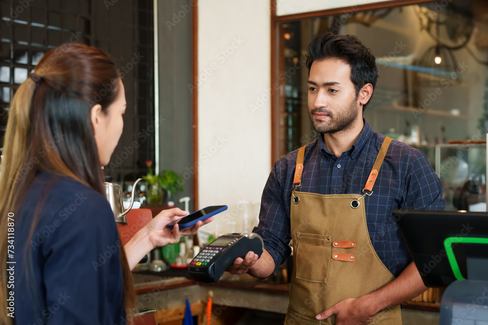 Male cafe employees of various nationalities holding credit card