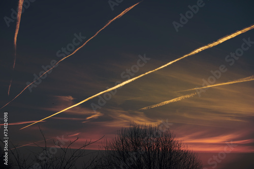 smoke trails left by planes on London sky at sunshine