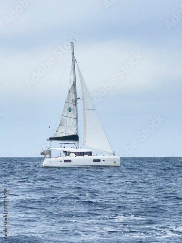 a catamaran sailing in the open ocean © Zhanna