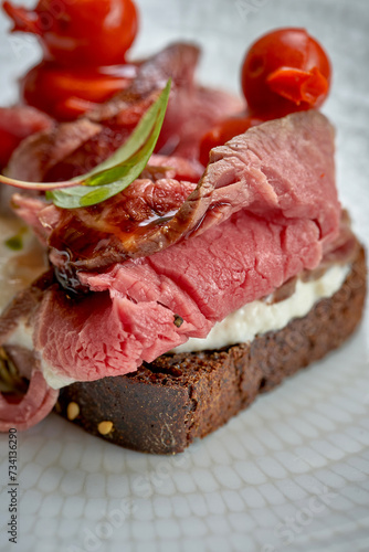 Toast with roast beef and vegetables in a plate