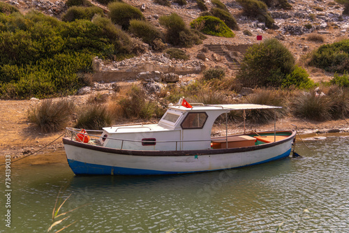 Close-up of a small wooden boat parked on a river on a sunny day, Turkey. Fishing boat parking © yaroslav1986
