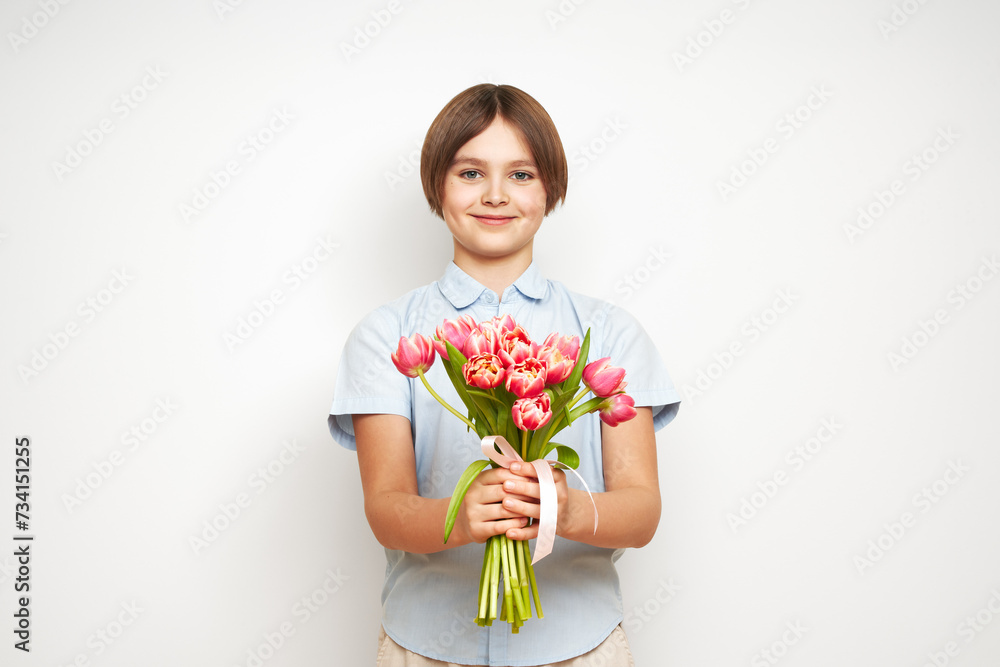 Cheerful happy child with Tulips bouquet. Smiling boy on white background. Mother's Day. Love and romantic concept Cheerful happy child with Tulips bouquet. Smiling boy on white background. Mother's Day. Love and romantic concept