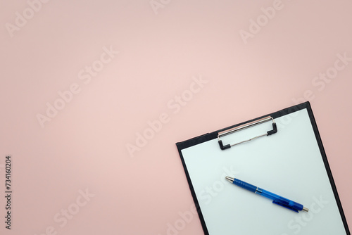Clipboard and pen with empty pages for writing and sketching on pink background for business and education concept