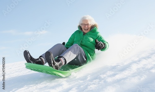 Crazy grandma is sledding down the hill on sledge. Active retirement concept