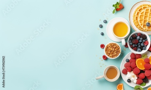 Top view of Healthy breakfast concept with fresh pancakes, berries, fruit on light blue backgroudt. Free space for your text.