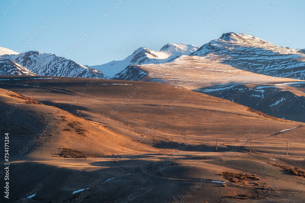 Fototapeta premium snowy mountain ridge illuminated by setting sun