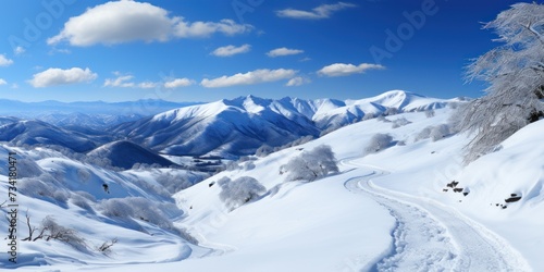 A snow-covered mountain landscape with a road cutting through it, showcasing the stark beauty of the winter terrain.