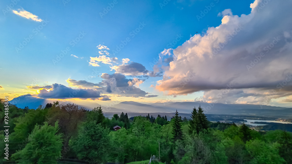 Obraz premium Scenic sunset view of mount Dobratsch and Lake Faak seen from Altfinkenstein at Baumgartnerhoehe, Carinthia, Austria. Tranquility on hiking trail. Overlooking Villach area surrounded by Austrian Alps